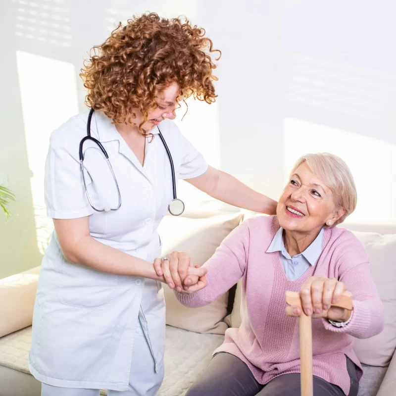 woman helping an older lady stand up