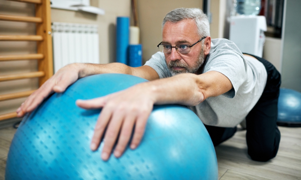 Patient performing rehabilitation exercises with physical therapist at home