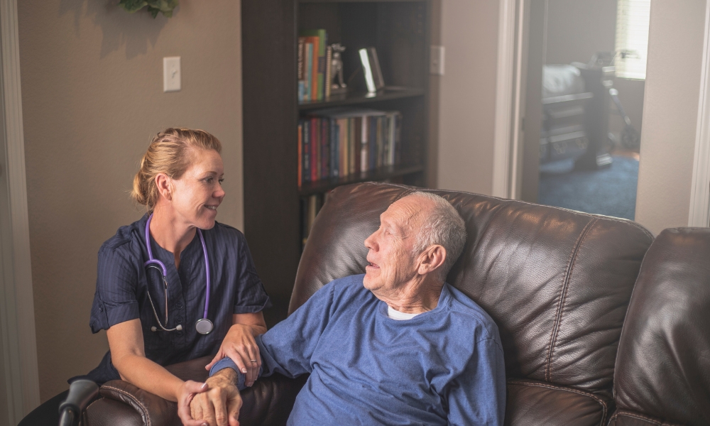 Home health nurse providing compassionate care to elderly patient at home